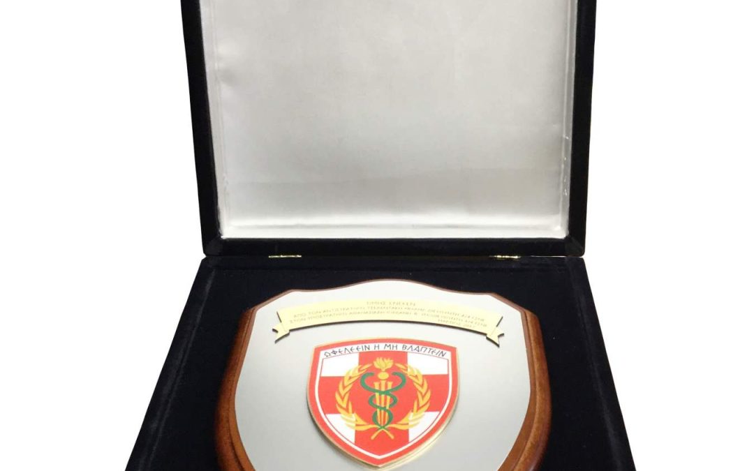 1. Πλακέτα (μεγάλο μέγεθος) από ξύλινη βάση με αλπακά 1,85×22 cm με το έμβλημα της μονάδος σε βελούδινη χειροποίητη κασετίνα